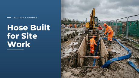 Groundworks crew working at a shored drainage trench with a blue PVC layflat discharge hose running across a muddy UK construction site